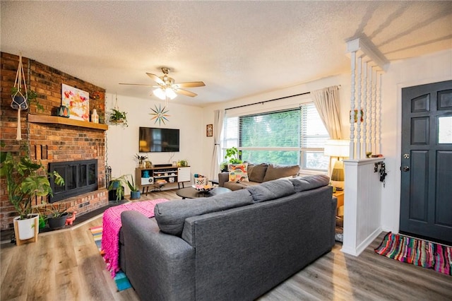 5 Chapel Ln, Bella Vista, AR 72715 - living area with wood finished floors, a textured ceiling, ceiling fan, and a fireplace