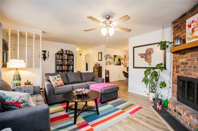 5 Chapel Ln, Bella Vista, AR 72715 - living area featuring wood finished floors, a brick fireplace, ceiling fan, and baseboards