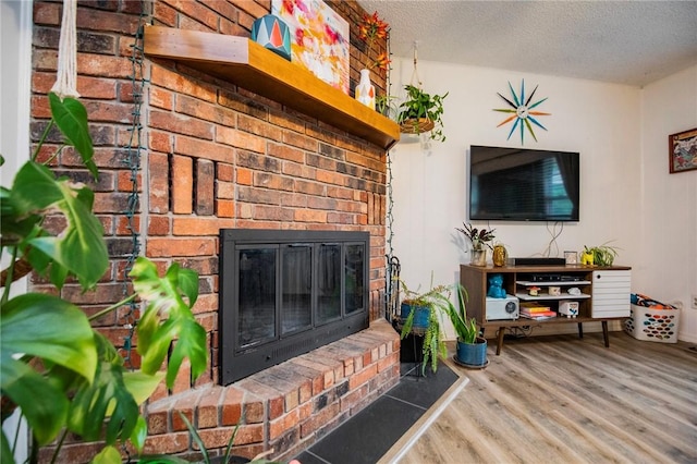 5 Chapel Ln, Bella Vista, AR 72715 - living area featuring wood finished floors, a brick fireplace, and a textured ceiling