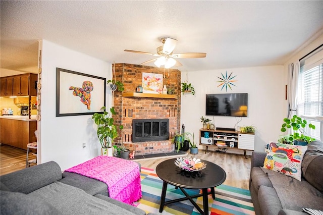 5 Chapel Ln, Bella Vista, AR 72715 - living area featuring wood finished floors, ceiling fan, a brick fireplace, and a textured ceiling