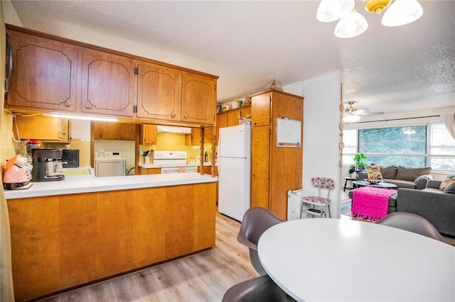 5 Chapel Ln, Bella Vista, AR 72715 - kitchen with white appliances, washer / dryer, light wood-style floors, a peninsula, and brown cabinets