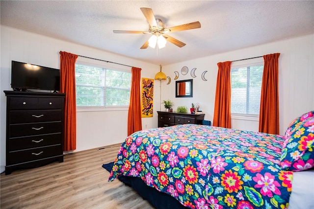 5 Chapel Ln, Bella Vista, AR 72715 - bedroom with wood finished floors, a ceiling fan, and a textured ceiling