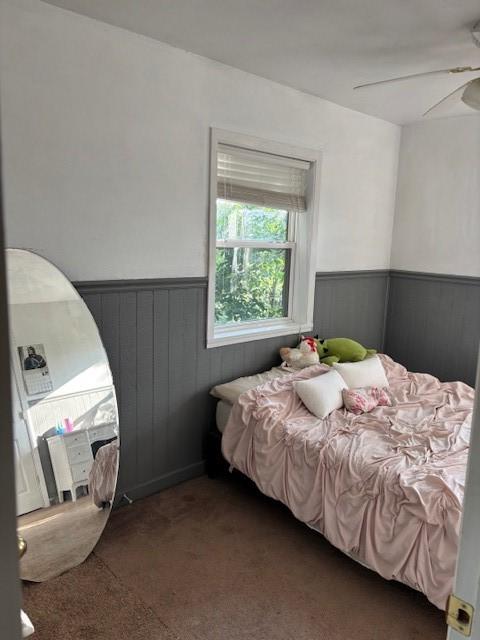 12883 Nickels Rd, West Fork, AR 72774 - bedroom featuring wainscoting, carpet flooring, a ceiling fan, and wooden walls