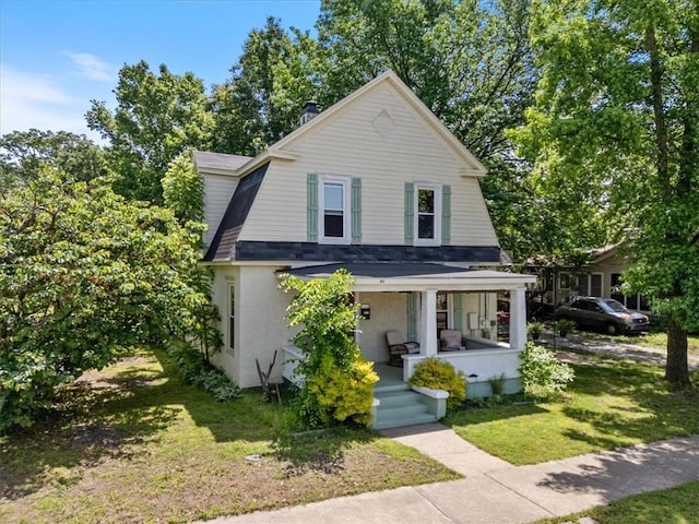 411 N Broadway St, Siloam Springs, AR 72761 - colonial inspired home with a porch, a front lawn, and stucco siding