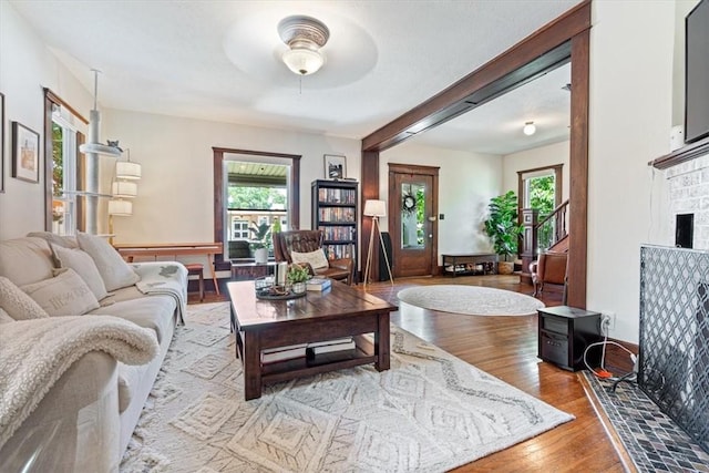411 N Broadway St, Siloam Springs, AR 72761 - living room with ceiling fan, plenty of natural light, wood finished floors, a brick fireplace, and beamed ceiling