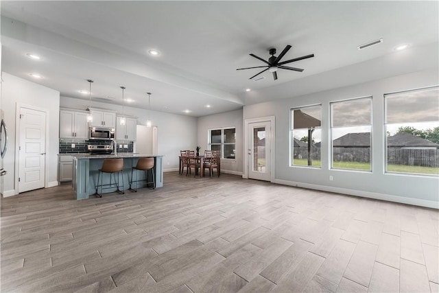 483 N Otoe St, Farmington, AR 72730 - kitchen with appliances with stainless steel finishes, open floor plan, a kitchen breakfast bar, light wood-style flooring, and recessed lighting