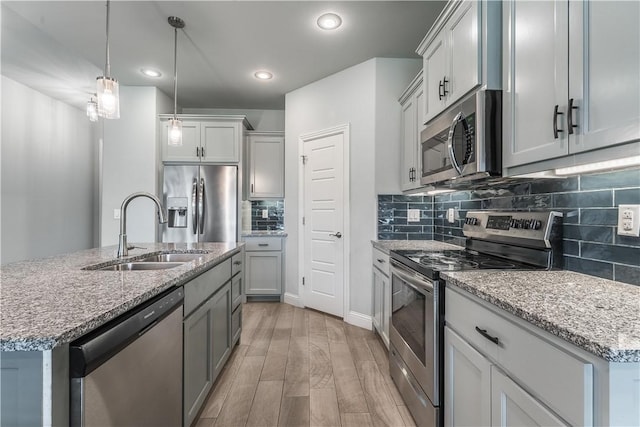 483 N Otoe St, Farmington, AR 72730 - kitchen with appliances with stainless steel finishes, a sink, light wood finished floors, backsplash, and light stone countertops