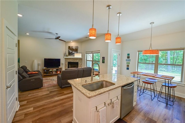 29 Bassingham Dr, Bella Vista, AR 72715 - kitchen featuring a sink, dishwasher, dark wood-style floors, a fireplace, and pendant lighting