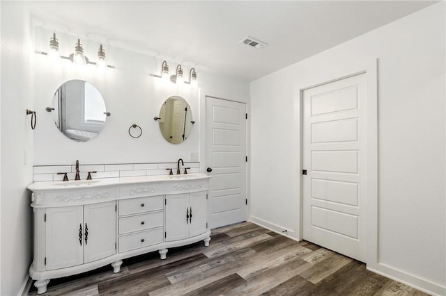 12698 Bush Rd, Centerton, AR 72719 - bathroom with double vanity, wood finished floors, and baseboards