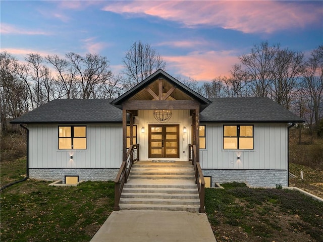12698 Bush Rd, Centerton, AR 72719 - view of front of home with board and batten siding, roof with shingles, french doors, covered porch, and a yard