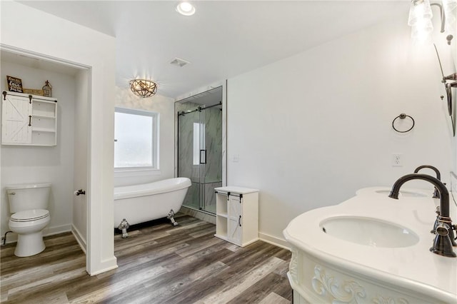 12698 Bush Rd, Centerton, AR 72719 - bathroom with a freestanding bath, a shower stall, wood finished floors, double vanity, and toilet