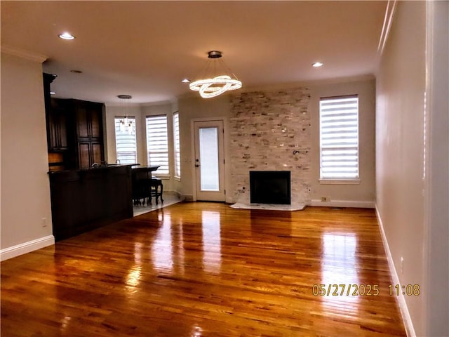 4007 Georgia St, Springdale, AR 72762 - unfurnished living room featuring a chandelier, wood finished floors, healthy amount of natural light, crown molding, and recessed lighting