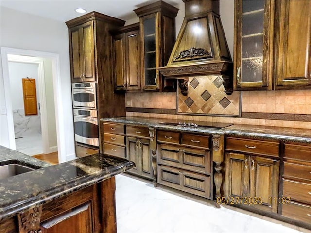4007 Georgia St, Springdale, AR 72762 - kitchen featuring premium range hood, light marble finish floors, dark stone counters, decorative backsplash, and glass insert cabinets