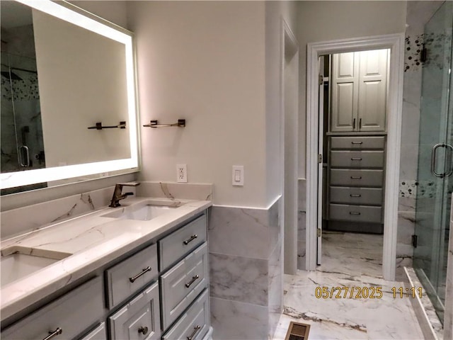 4007 Georgia St, Springdale, AR 72762 - full bathroom with double vanity, marble finish floors, a stall shower, tile walls, and wainscoting