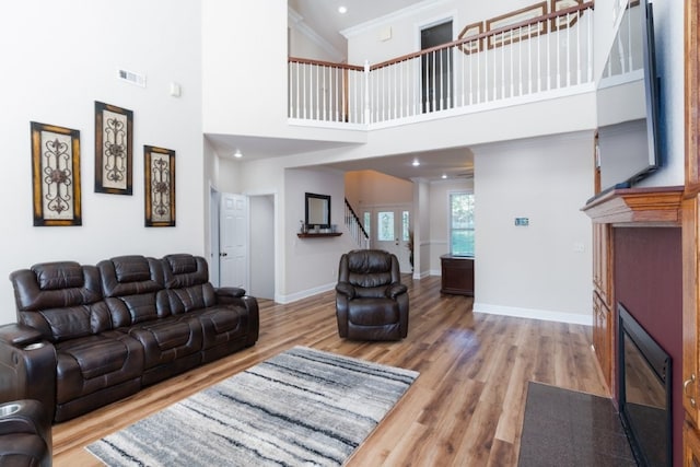 15210 Haynes Rd, Rogers, AR 72756 - living room featuring a fireplace with flush hearth, stairs, wood finished floors, baseboards, and a high ceiling
