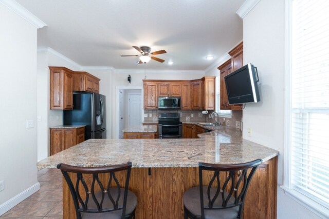 15210 Haynes Rd, Rogers, AR 72756 - kitchen with stainless steel microwave, electric range, a sink, a peninsula, and a ceiling fan