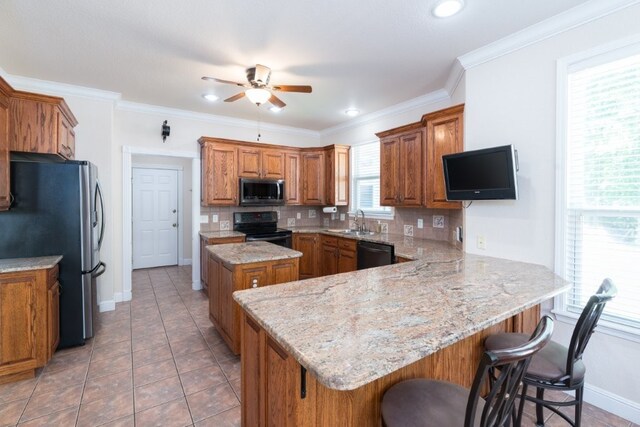 15210 Haynes Rd, Rogers, AR 72756 - kitchen with black appliances, brown cabinetry, a ceiling fan, a peninsula, and tasteful backsplash