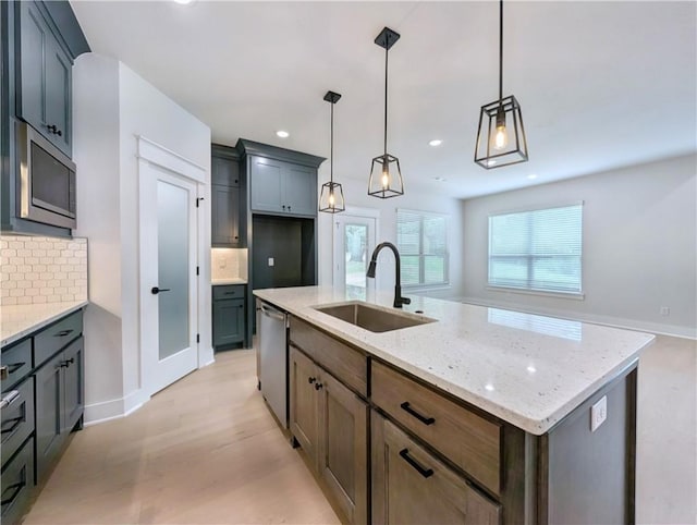 1 Darten Cir, Bella Vista, AR 72714 - kitchen with a sink, stainless steel appliances, backsplash, light stone countertops, and a kitchen island with sink