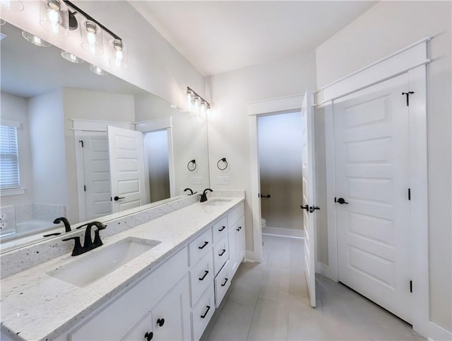 1 Darten Cir, Bella Vista, AR 72714 - bathroom featuring double vanity, toilet, tile patterned flooring, a bath, and baseboards