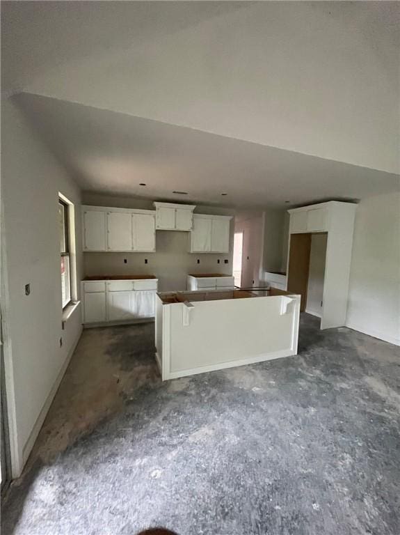 32 Buckland Ln, Bella Vista, AR 72715 - kitchen featuring a center island, dark colored carpet, and white cabinetry