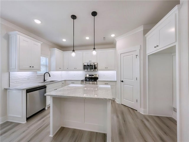 13 Epping Dr, Bella Vista, AR 72714 - kitchen with stainless steel appliances, a sink, light wood-style flooring, white cabinets, and crown molding