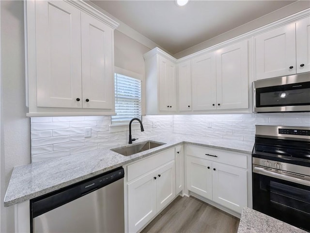 13 Epping Dr, Bella Vista, AR 72714 - kitchen with appliances with stainless steel finishes, a sink, white cabinetry, and tasteful backsplash