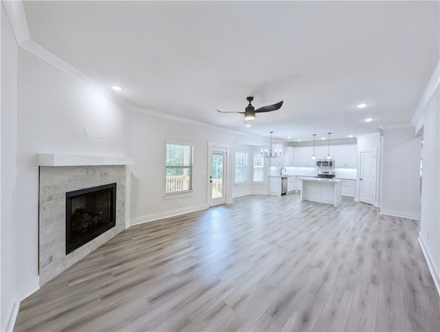 13 Epping Dr, Bella Vista, AR 72714 - unfurnished living room with ornamental molding, ceiling fan, a fireplace, baseboards, and light wood-style flooring
