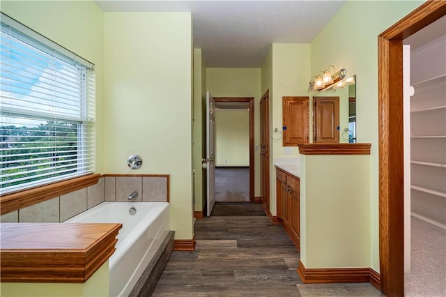 17 La Costa Dr, Holiday Island, AR 72631 - bathroom featuring vanity, a bath, wood finished floors, and baseboards