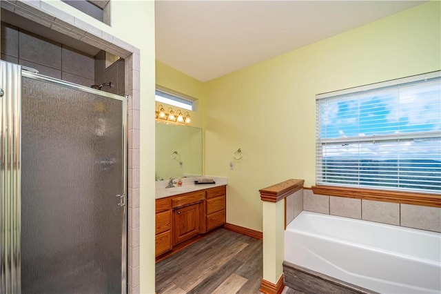 17 La Costa Dr, Holiday Island, AR 72631 - bathroom featuring wood finished floors, a shower stall, vanity, a garden tub, and baseboards
