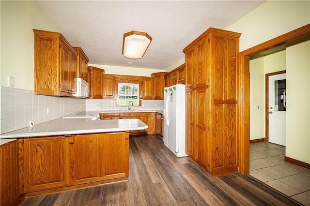 17 La Costa Dr, Holiday Island, AR 72631 - kitchen with white appliances, a peninsula, light countertops, and brown cabinetry
