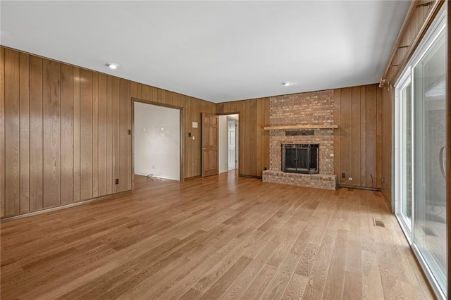 5 Rolling Meadows Dr, Harrison, AR 72601 - unfurnished living room featuring light wood-style floors, wood walls, and a brick fireplace