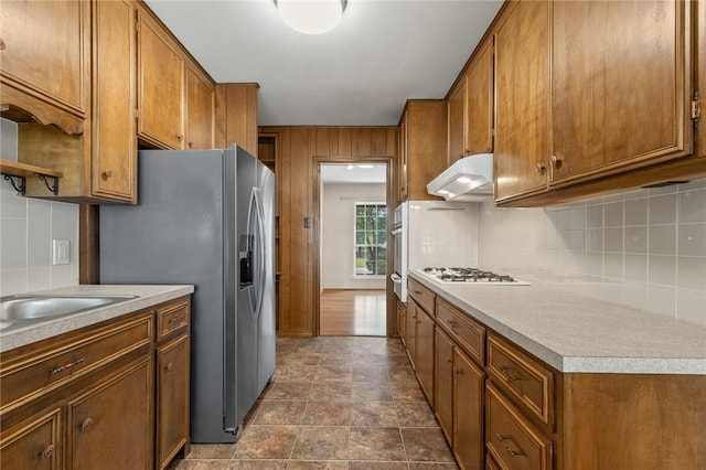 5 Rolling Meadows Dr, Harrison, AR 72601 - kitchen featuring under cabinet range hood, brown cabinetry, tasteful backsplash, light countertops, and appliances with stainless steel finishes