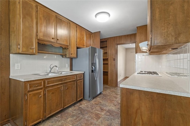 5 Rolling Meadows Dr, Harrison, AR 72601 - kitchen with a sink, stainless steel fridge, decorative backsplash, brown cabinets, and wooden walls