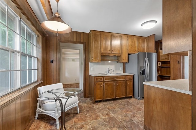 5 Rolling Meadows Dr, Harrison, AR 72601 - kitchen featuring brown cabinets, stainless steel refrigerator with ice dispenser, a sink, wooden walls, and light countertops