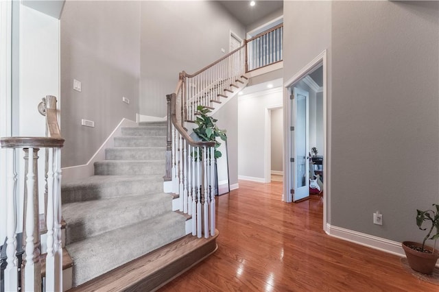 2314 S The Peaks Blvd, Rogers, AR 72758 - staircase with baseboards, wood finished floors, and a towering ceiling