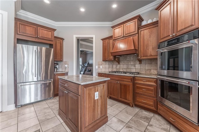 2314 S The Peaks Blvd, Rogers, AR 72758 - kitchen featuring appliances with stainless steel finishes, premium range hood, a kitchen island, brown cabinets, and tasteful backsplash