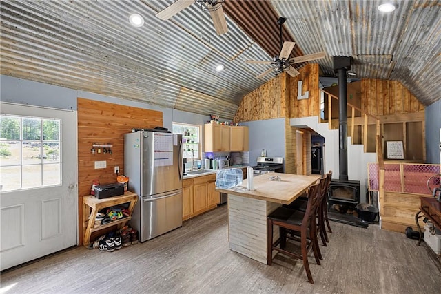 439 Pine Twist, Russellville, AR 72802 - kitchen featuring appliances with stainless steel finishes, ceiling fan, a wood stove, vaulted ceiling, and light wood-style floors