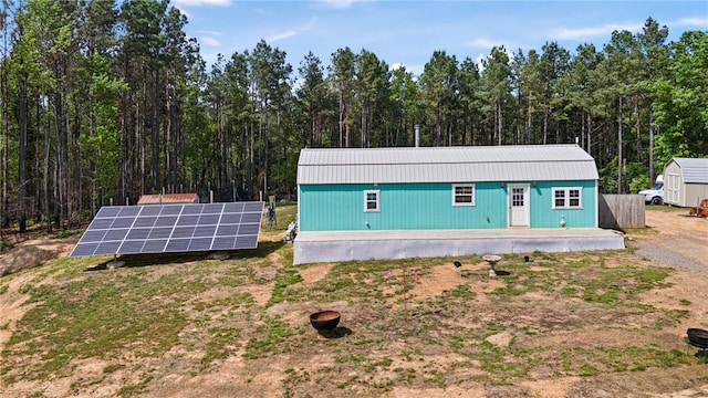 439 Pine Twist, Russellville, AR 72802 - view of outdoor structure featuring solar panels and a wooded view