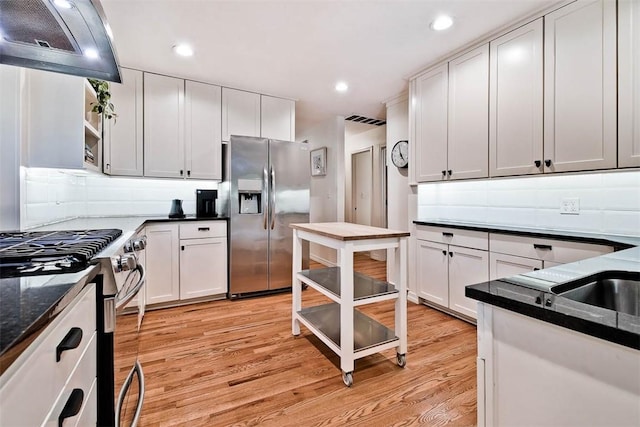 1463 E Woodbrook Dr, Fayetteville, AR 72703 - kitchen with stainless steel appliances, ventilation hood, light wood-style floors, white cabinetry, and recessed lighting