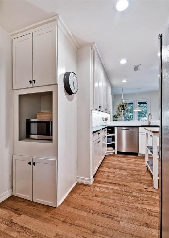1463 E Woodbrook Dr, Fayetteville, AR 72703 - bar featuring appliances with stainless steel finishes, light wood-style floors, baseboards, recessed lighting, and a sink