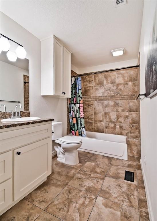 1463 E Woodbrook Dr, Fayetteville, AR 72703 - bathroom featuring toilet, vanity, shower / tub combo with curtain, tile patterned flooring, and a textured ceiling