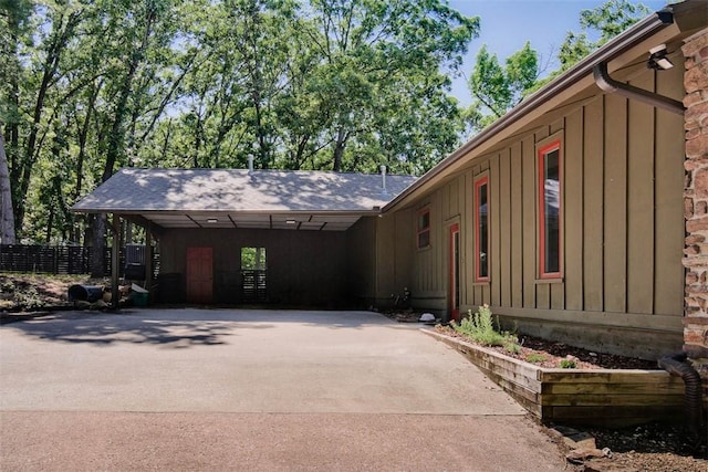 1463 E Woodbrook Dr, Fayetteville, AR 72703 - view of front facade featuring board and batten siding, concrete driveway, and a carport