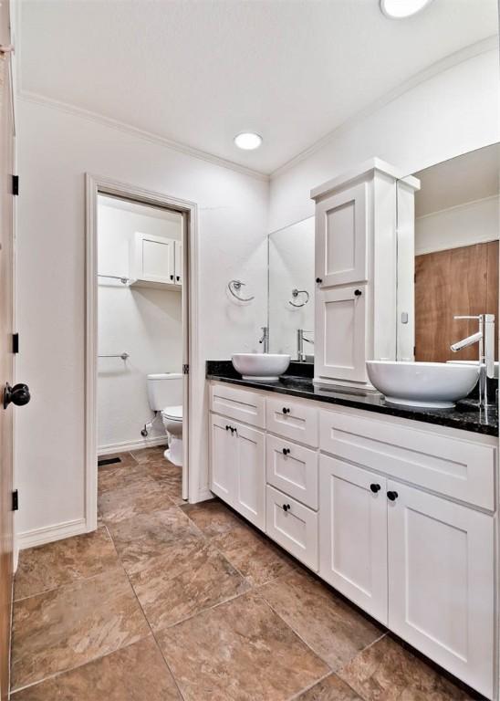 1463 E Woodbrook Dr, Fayetteville, AR 72703 - full bathroom with double vanity, toilet, ornamental molding, and baseboards