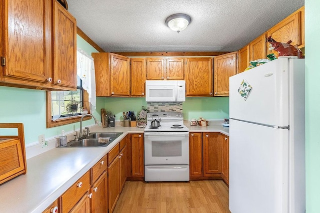 1188 Kyle Rd, Noel, MO 64854 - kitchen with white appliances, a sink, light countertops, light wood finished floors, and brown cabinets