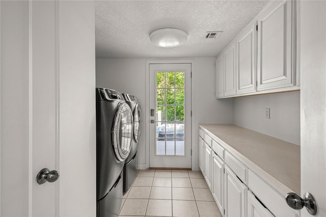 3307 NW 3rd St, Bentonville, AR 72712 - laundry room featuring washing machine and dryer, cabinet space, a textured ceiling, and light tile patterned flooring