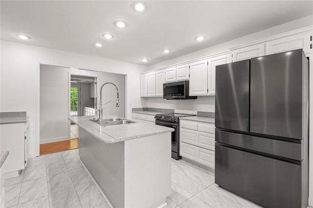 3307 NW 3rd St, Bentonville, AR 72712 - kitchen featuring freestanding refrigerator, electric range, a sink, white cabinets, and an island with sink