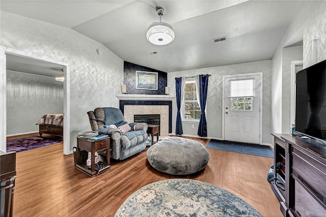 64 Cheryl Cir, Bentonville, AR 72712 - living area featuring wood finished floors, vaulted ceiling, and a fireplace