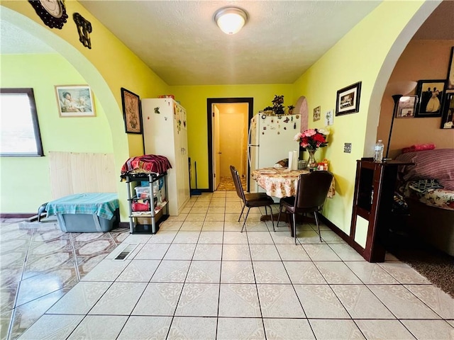 720 Circle Dr, Berryville, AR 72616 - dining room with arched walkways, light tile patterned flooring, baseboards, and a textured ceiling