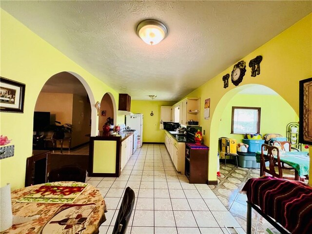 720 Circle Dr, Berryville, AR 72616 - kitchen featuring white appliances, a textured ceiling, light tile patterned floors, and dark countertops
