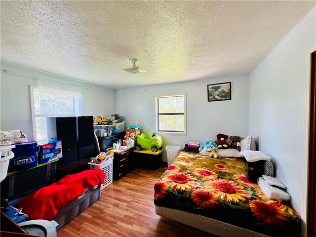 720 Circle Dr, Berryville, AR 72616 - bedroom featuring a textured ceiling and wood finished floors